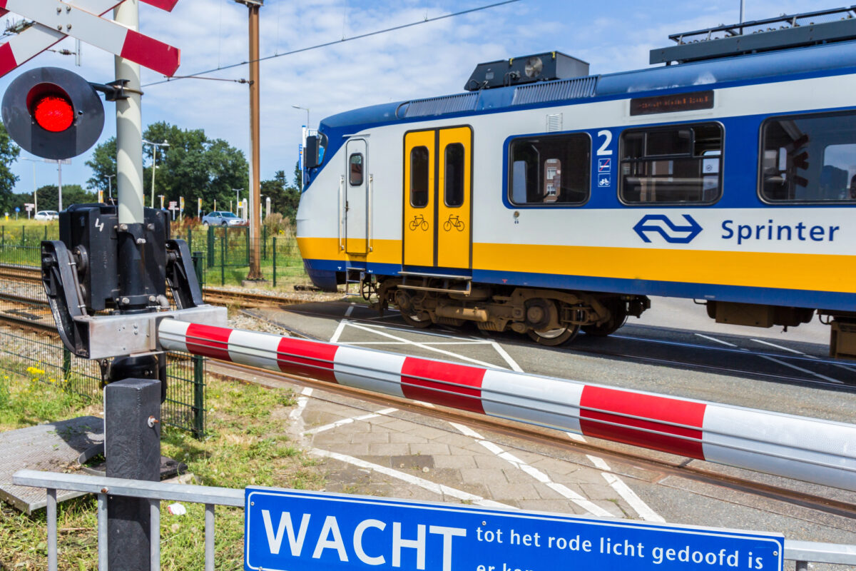 Modern passenger train traveling through green countryside near Dutch-Belgian border region