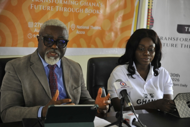 Books displayed at Ghana International Book Fair with publishers and readers browsing exhibits