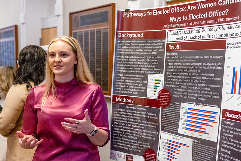 Undergraduate students presenting research posters at Meredith College's annual achievement celebration event