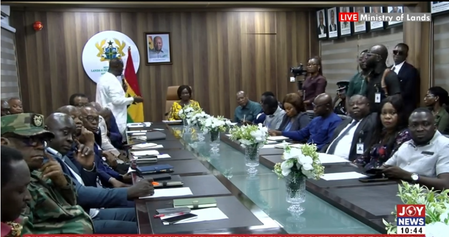 Ghanaian community leaders review documents at district mining committee meeting table