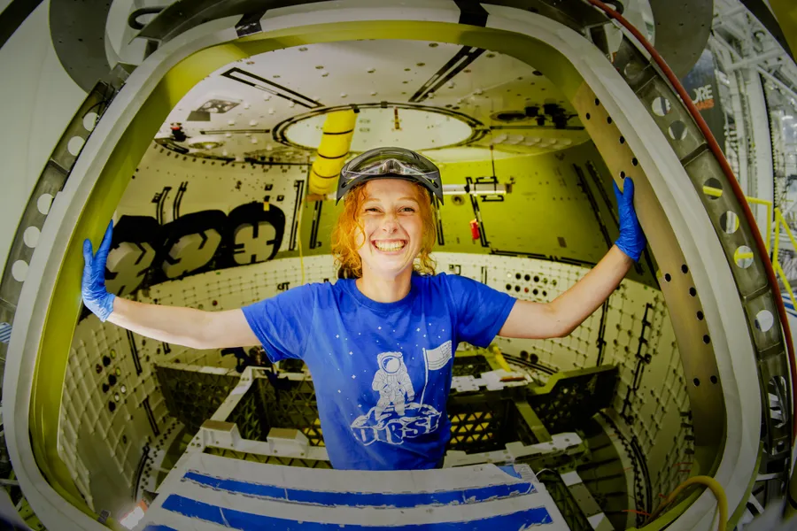 Mechanical technician Rebekah Tolatovitz working inside Artemis III Orion crew module at Kennedy Space Center