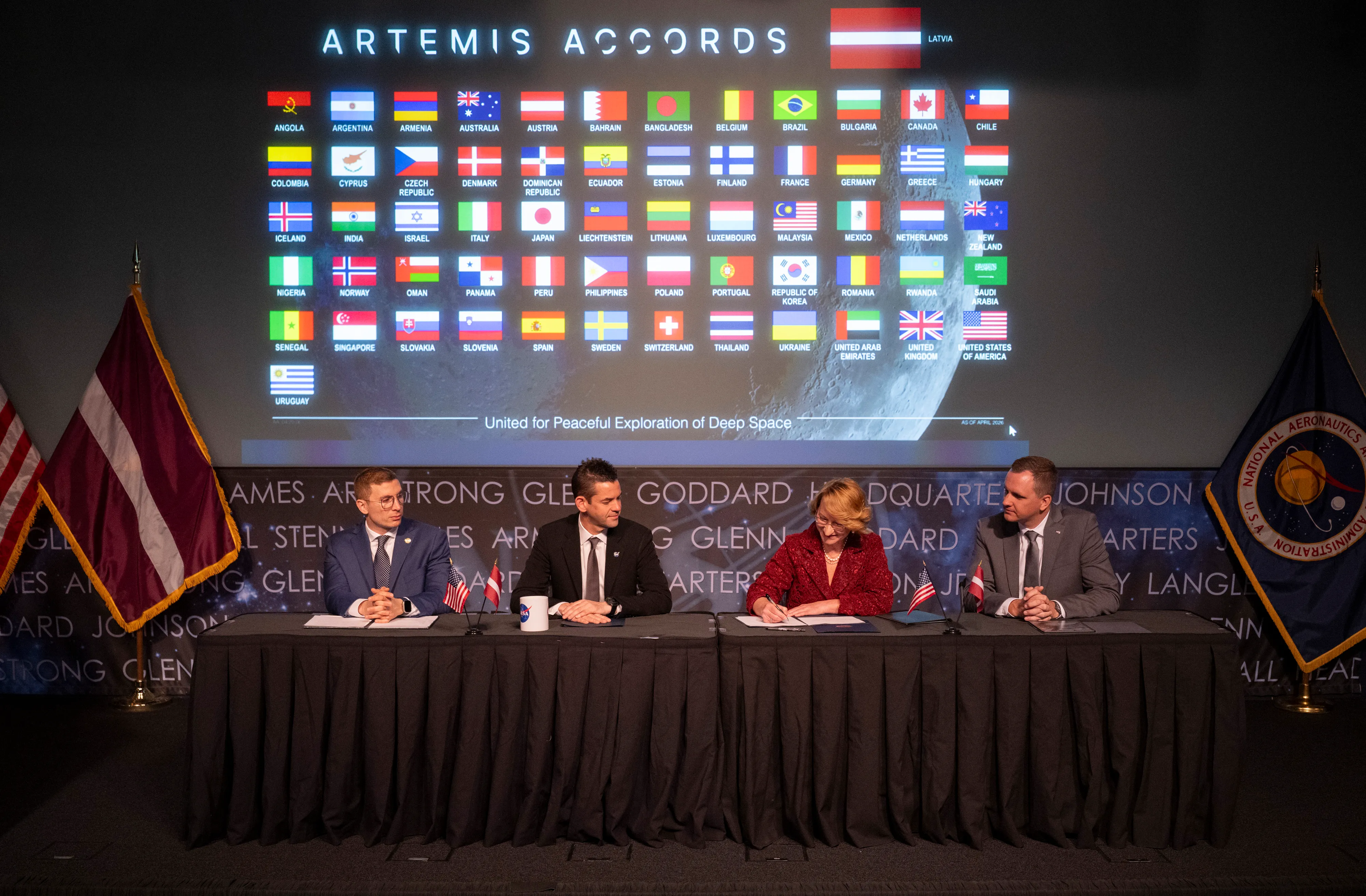 Latvia's Education Minister Dace Melbārde signs Artemis Accords at NASA headquarters with officials watching