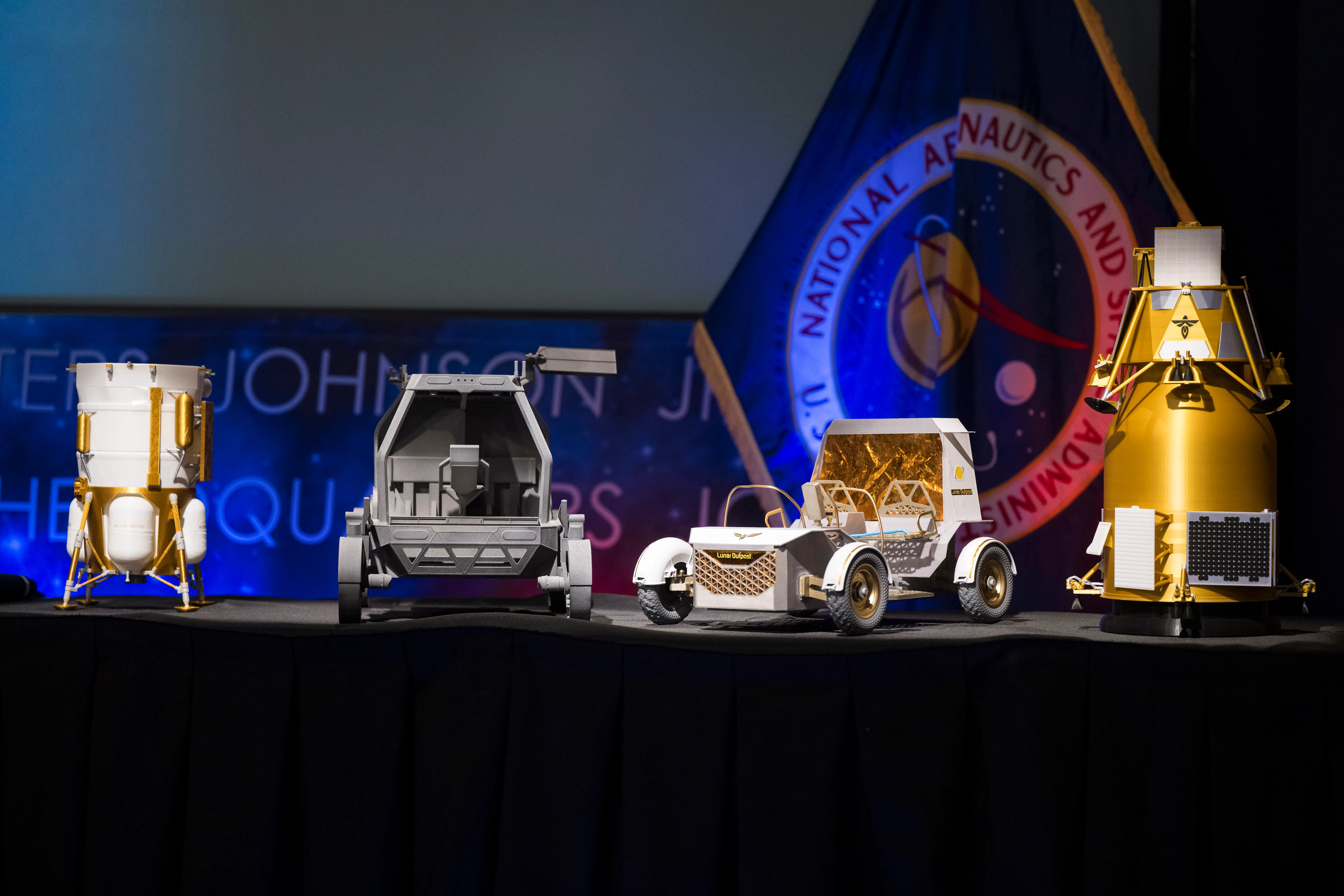 Four lunar vehicle models displayed at NASA headquarters Moon Base announcement event