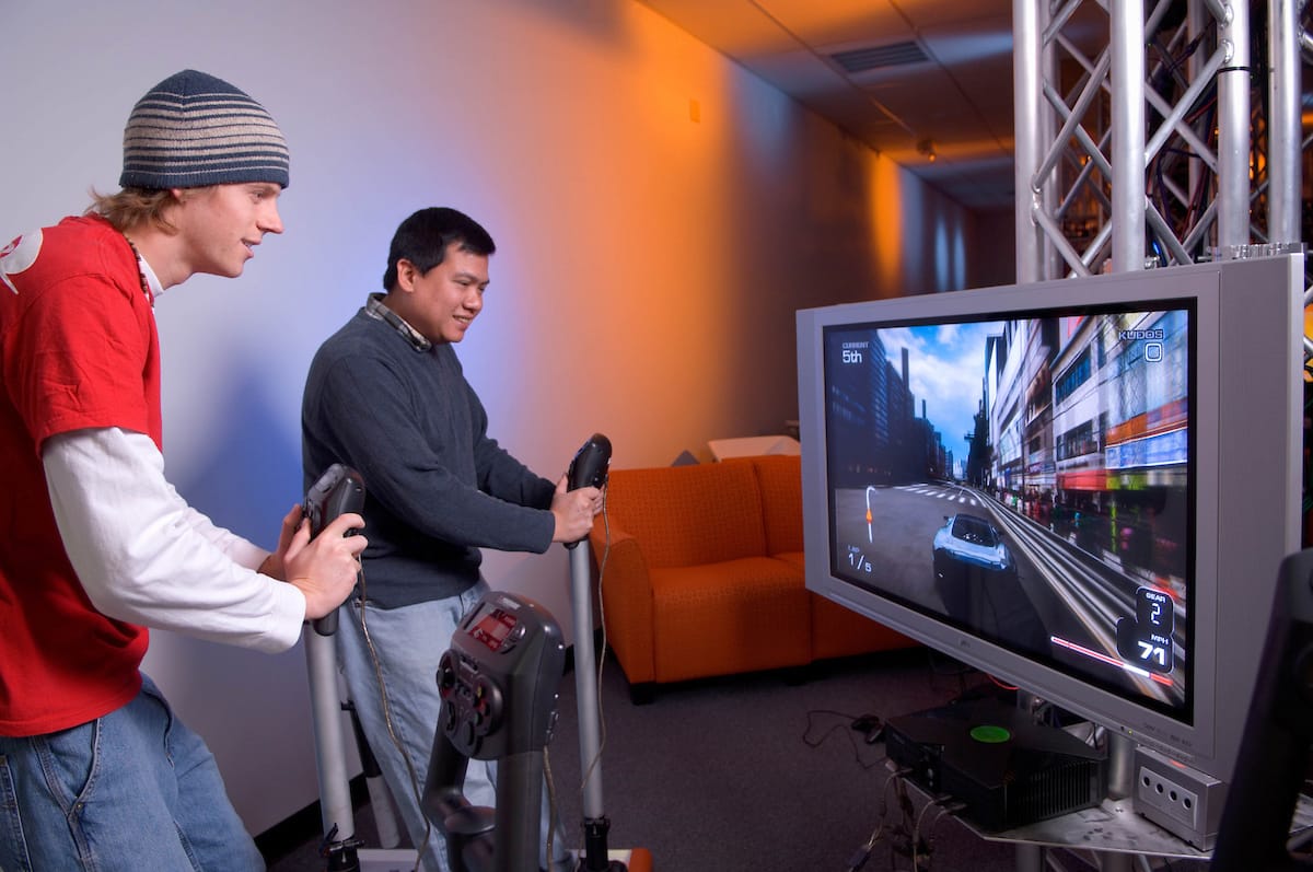 Students wearing VR headsets working in Ohio University's immersive technology laboratory with gaming equipment