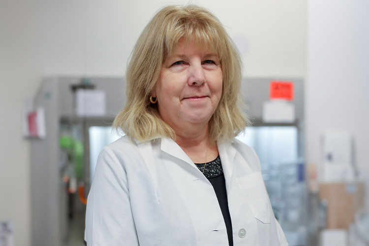 Research scientist Dr. Carol Webb working in laboratory studying lupus protein treatments