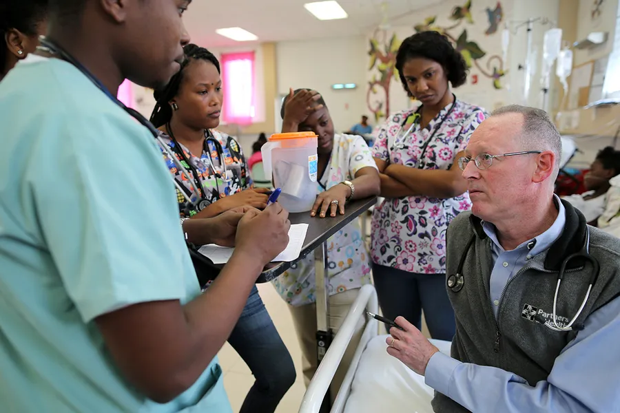** Dr. Paul Farmer consulting with medical staff at hospital in rural Haiti in 2016