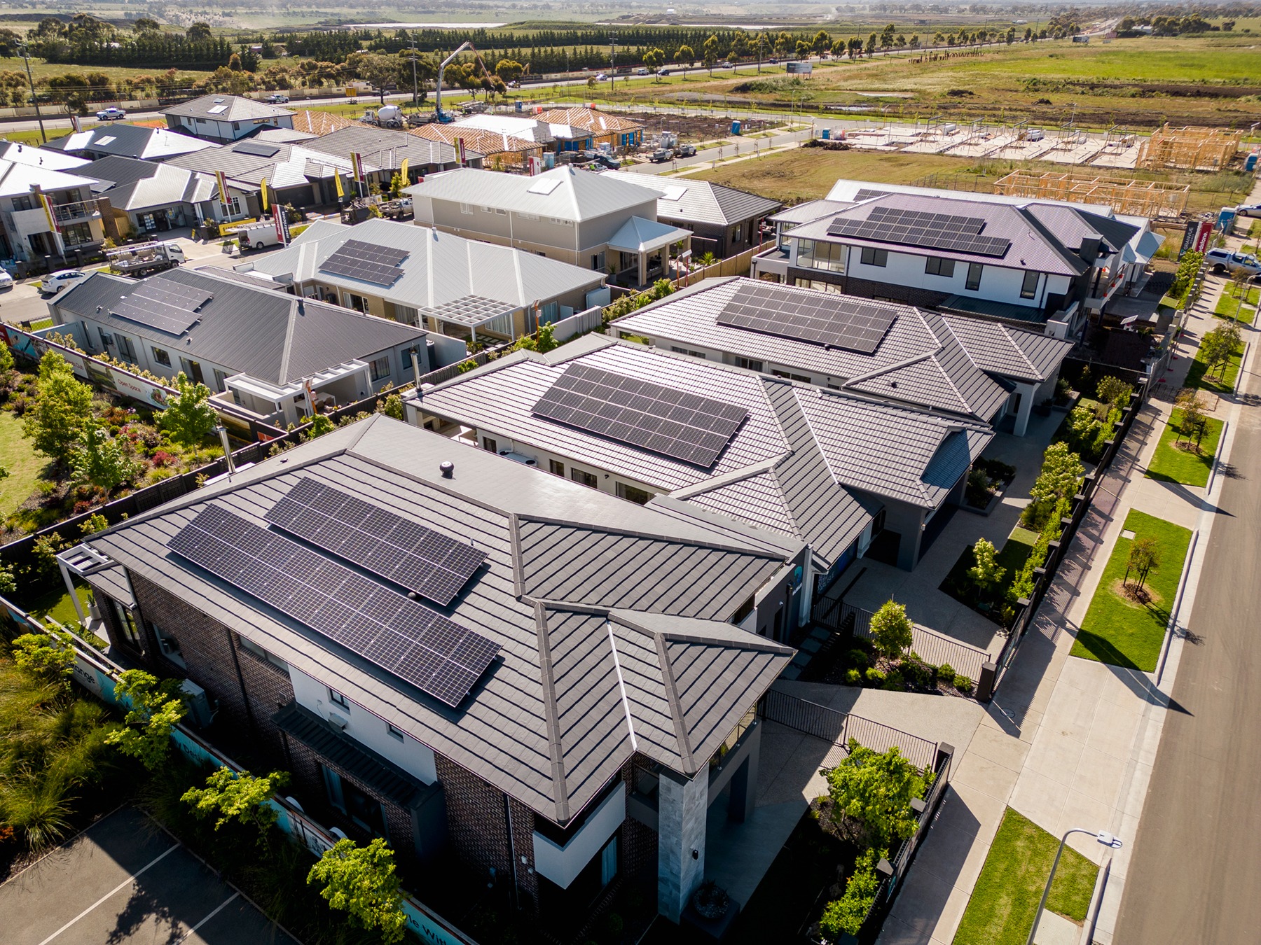 Rows of blue solar panels installed on residential rooftops under bright Australian sunshine