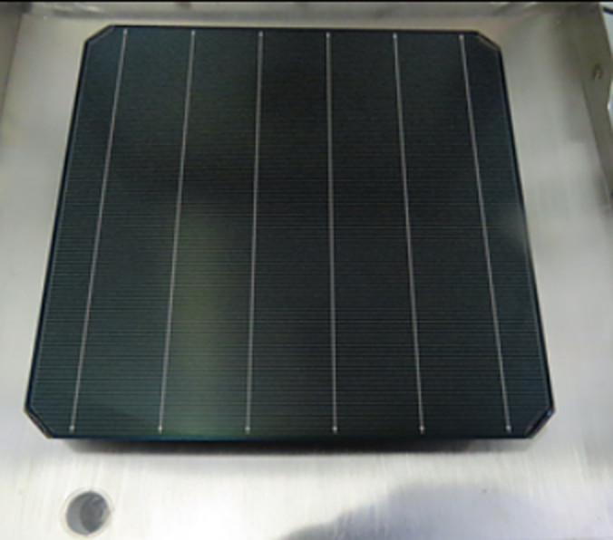 Close-up of solar cell wafer showing edge masking technique in research laboratory setting