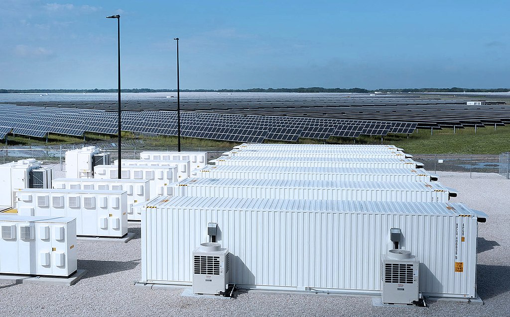 Large-scale solar panels and battery storage facility at sunset generating clean renewable electricity