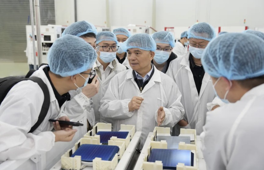 Modern solar panel manufacturing facility with rows of blue photovoltaic cells in production