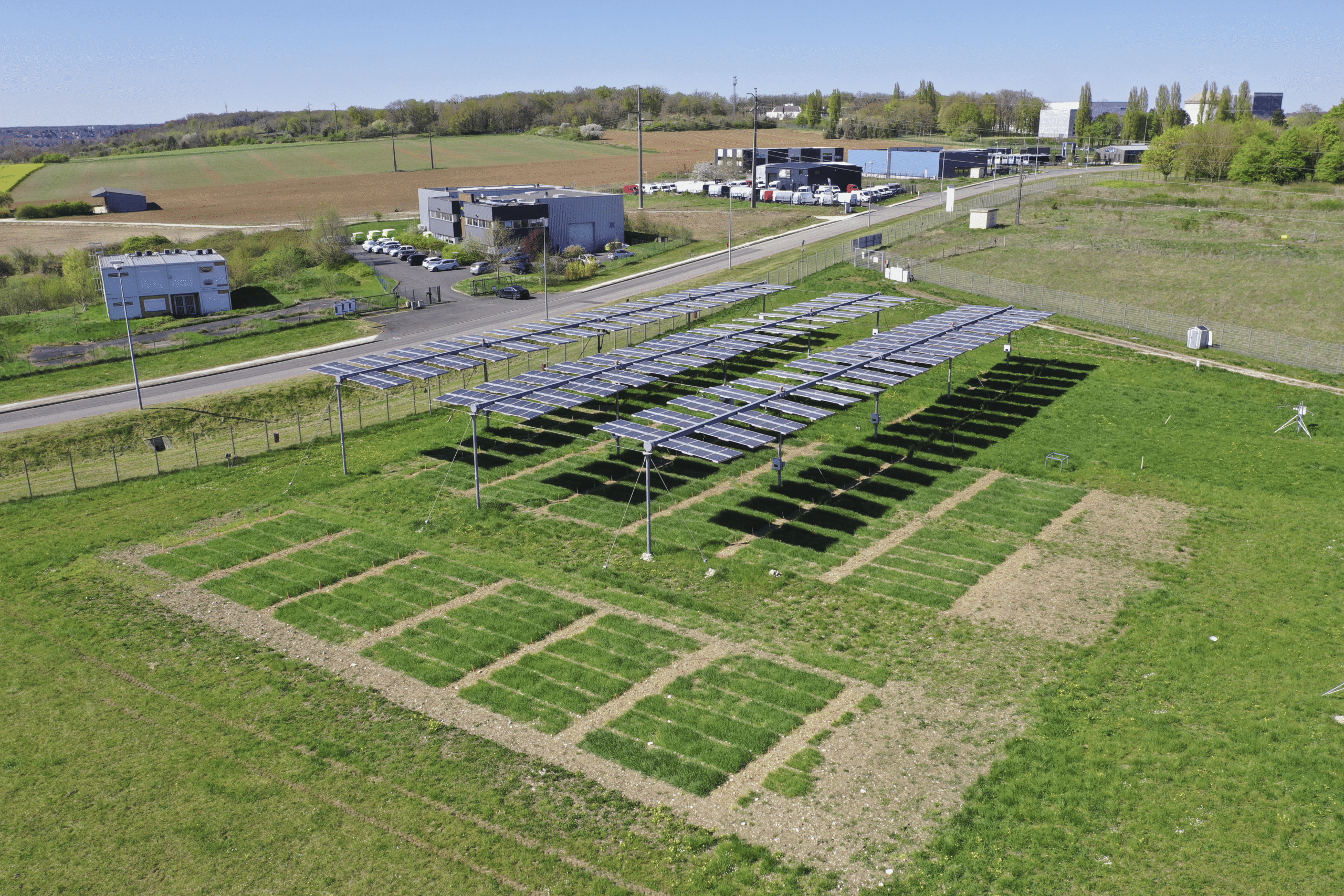 Solar panels mounted high above green crops on experimental farm in France