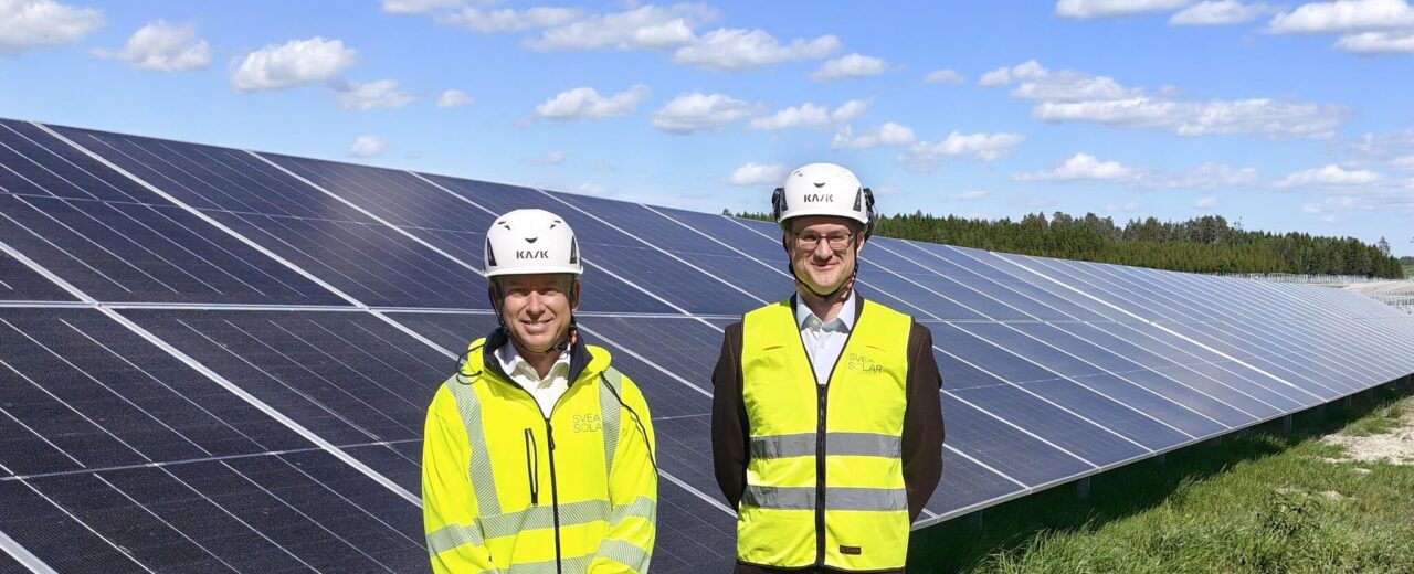 Solar panels stretching across Swedish landscape with battery storage facility nearby