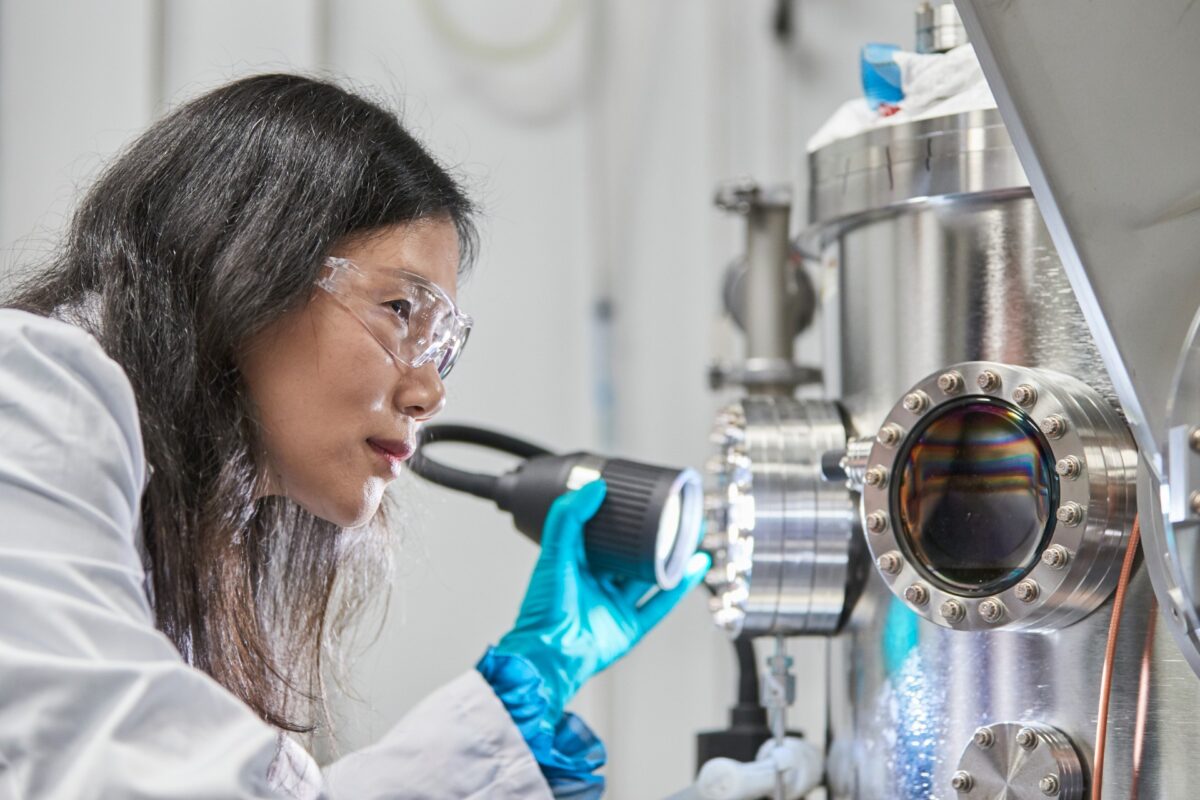 Scientist Xiaojing Hao examining eco-friendly copper zinc tin sulfide solar cell materials in laboratory