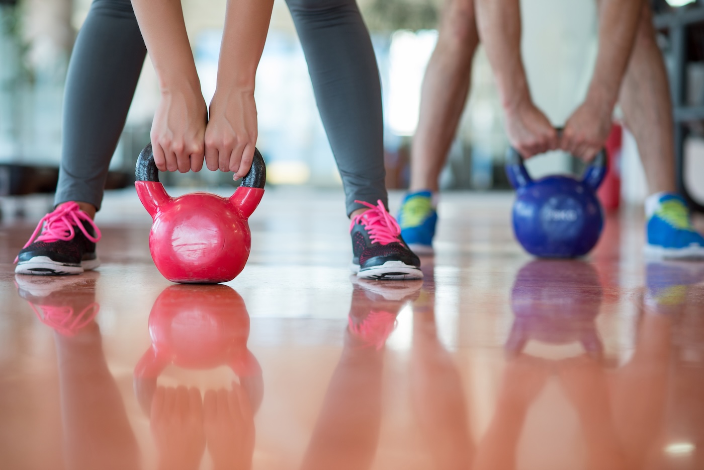 Cancer survivors exercising together in bright wellness center with supportive physical therapist guiding them