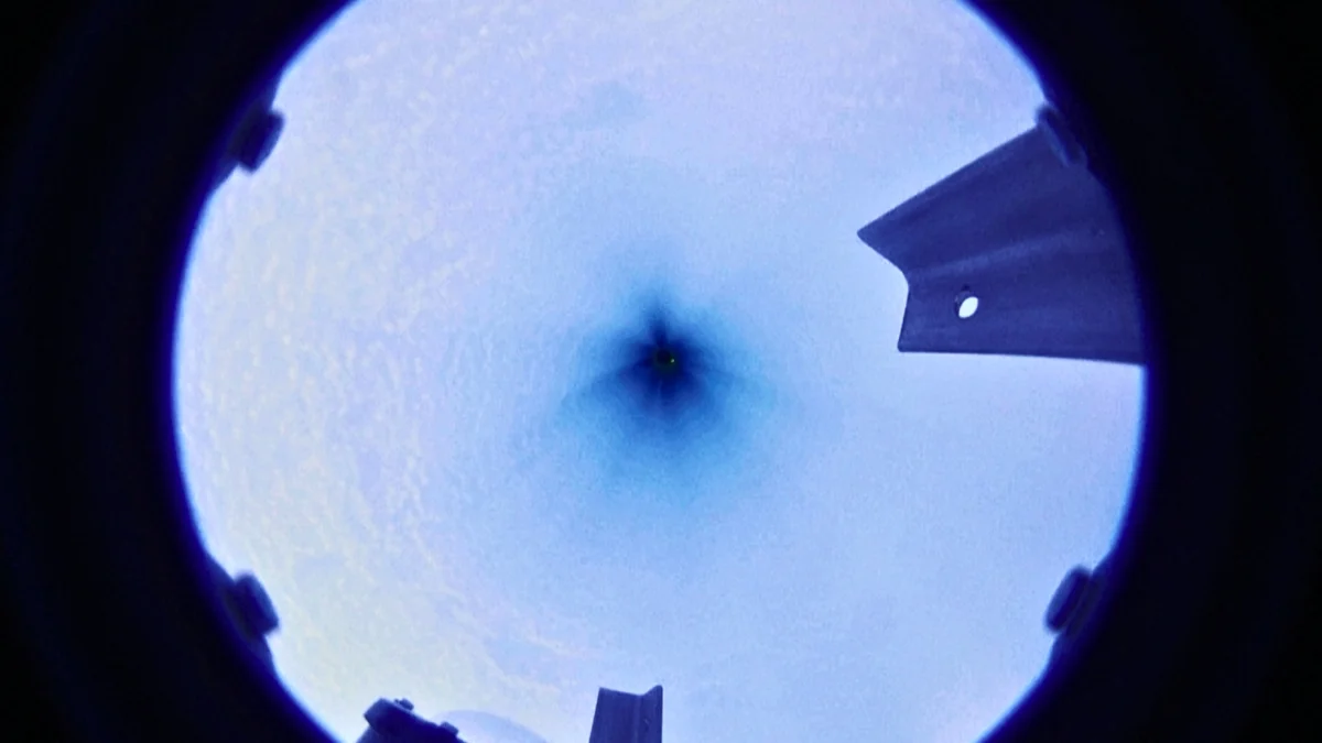 Scientific drilling equipment on white Antarctic ice shelf against blue sky