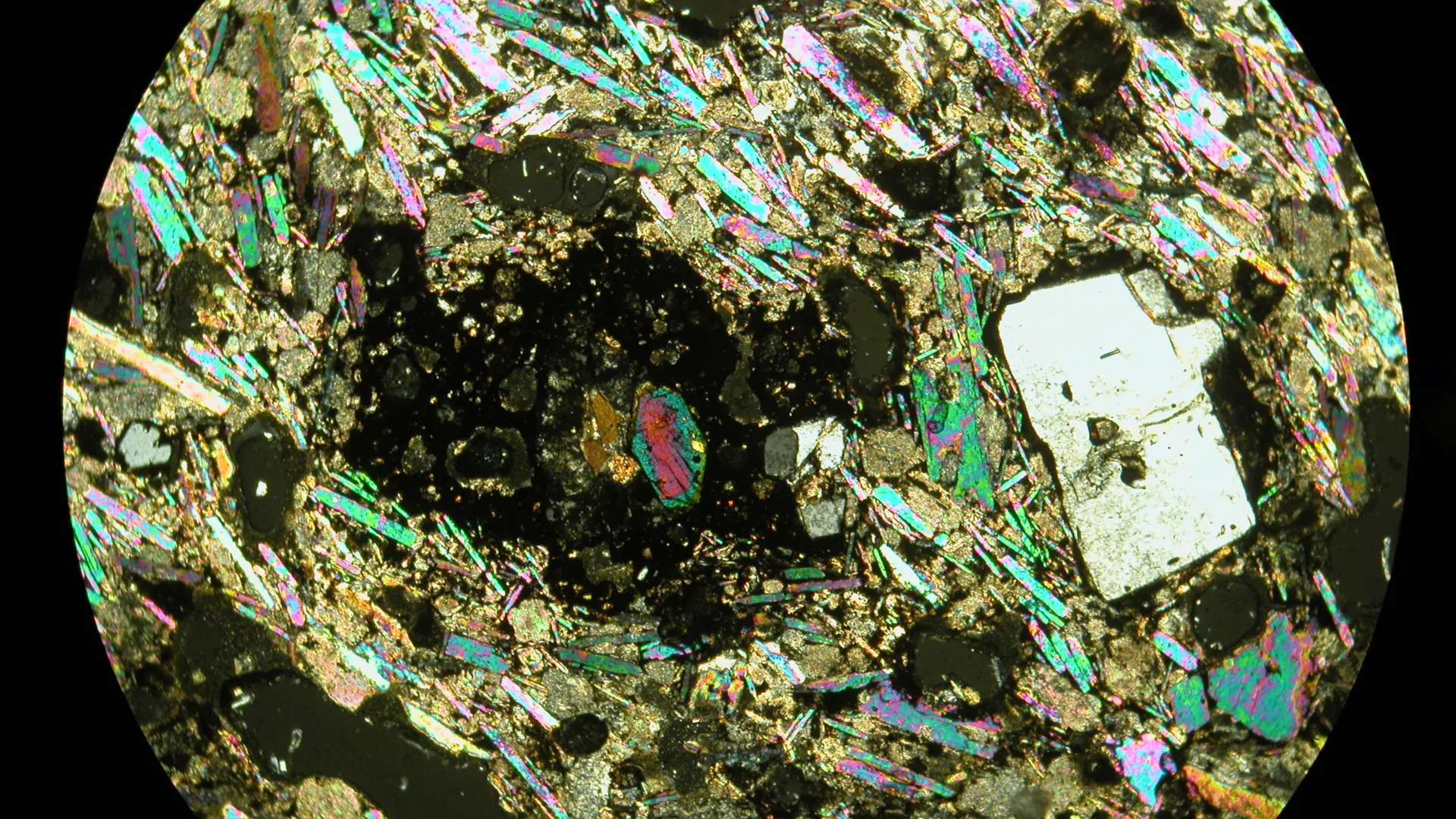 Microscope view of colorful rare earth element rich volcanic rock from Cambridge study