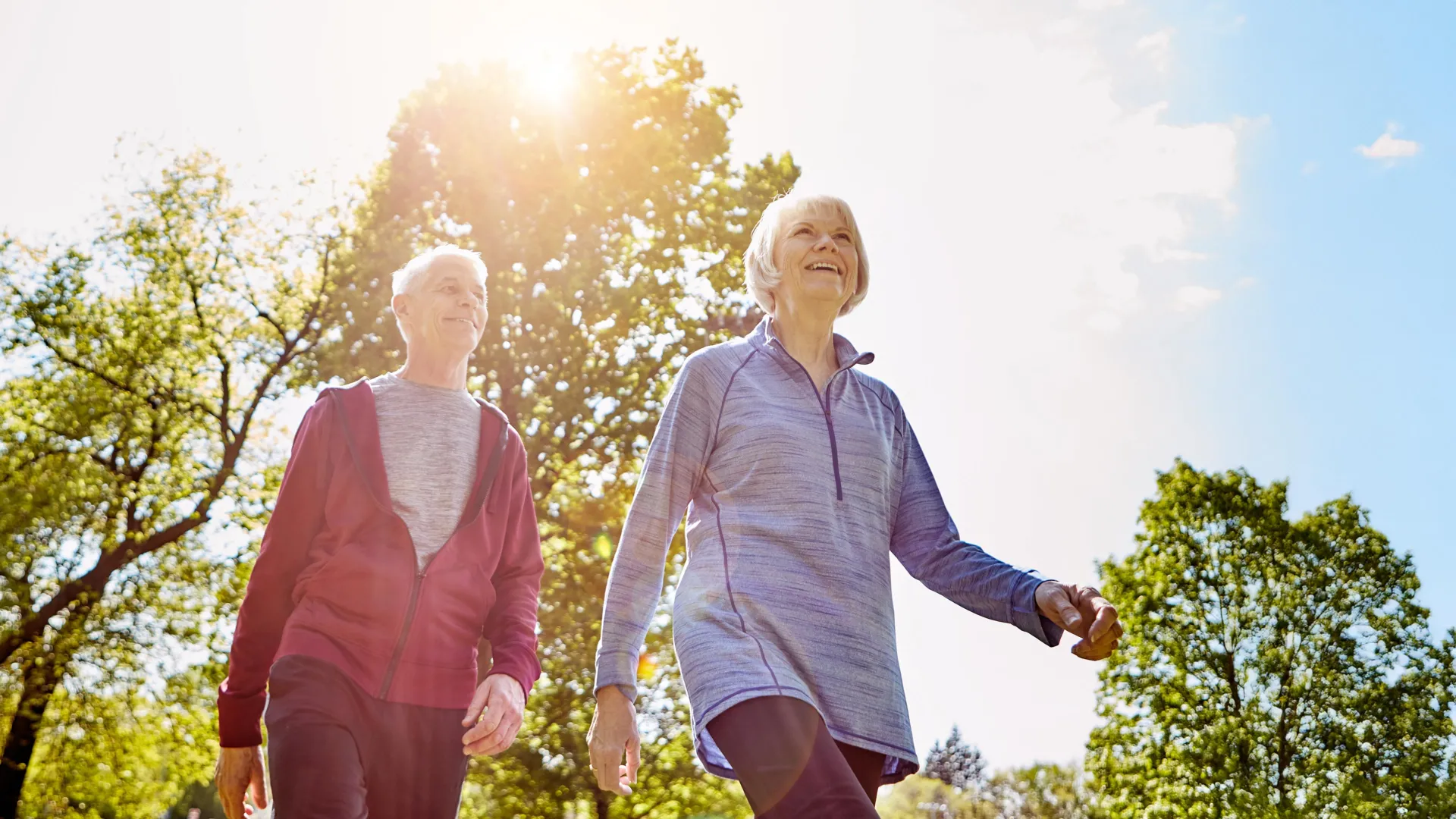 Older adult walking confidently outdoors on pathway demonstrating healthy mobility and active aging