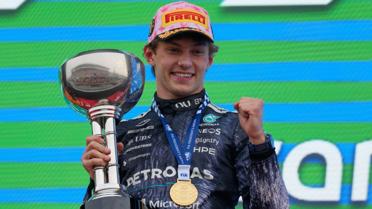 Teen Formula 1 driver Kimi Antonelli celebrates on podium after winning Japanese Grand Prix