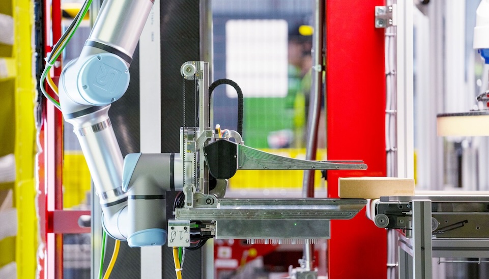 Robotic arm with sensors working in modern warehouse facility alongside AWS cloud technology