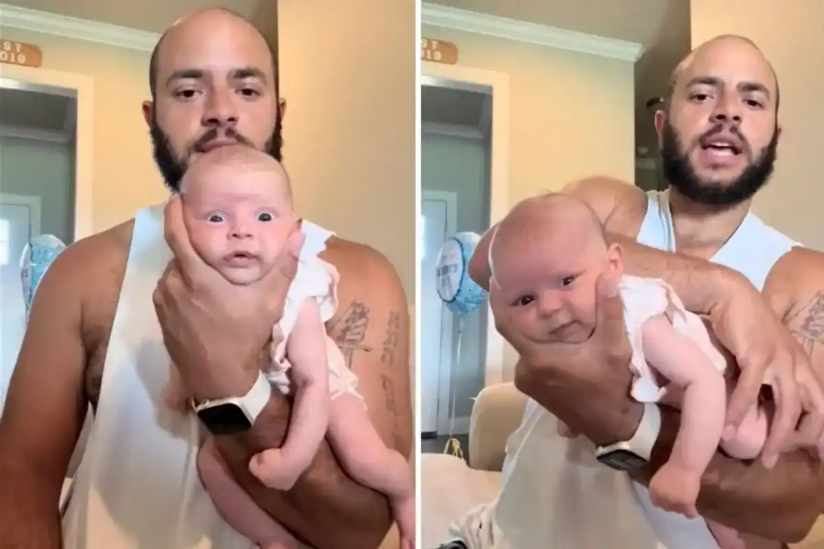 Father holding newborn baby daughter while filming TikTok video parody of Amazon product review