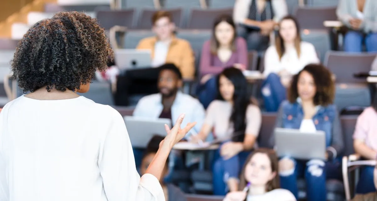 College students sitting in lecture hall during educational presentation about sexual assault awareness