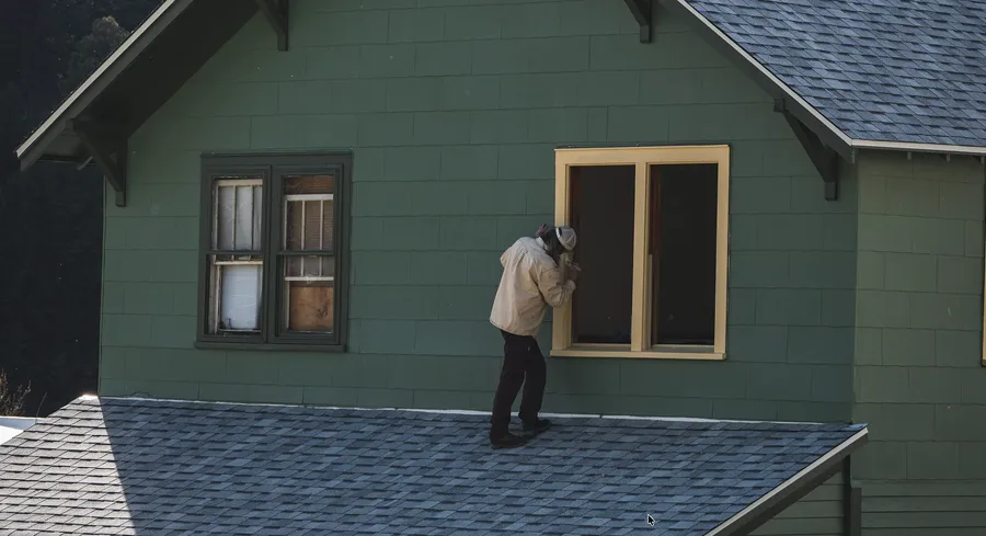 Elderly woman warming hands near home furnace on cold winter day