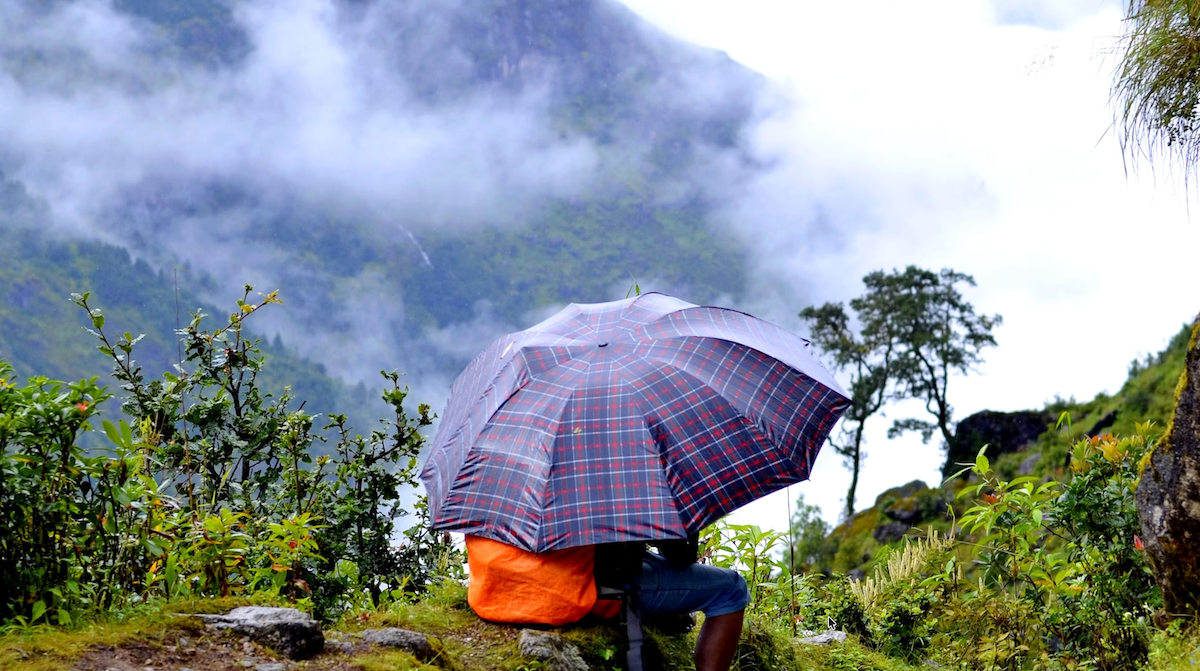 Young woman hiker smiling with mountain guides in Nepal's Langtang Valley region