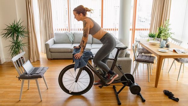 Person riding stationary exercise bike in bright fitness studio representing brain health benefits
