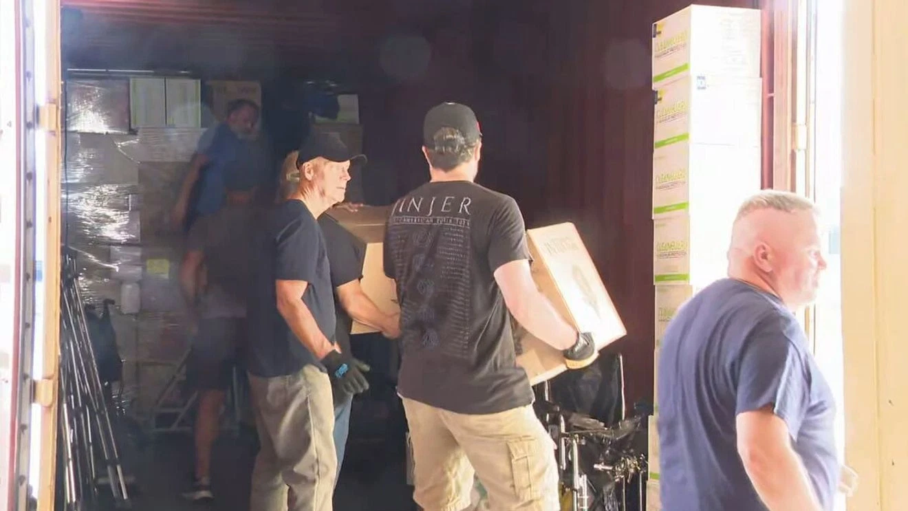 RocMaidan volunteers loading medical supplies and equipment into large shipping container for Ukraine