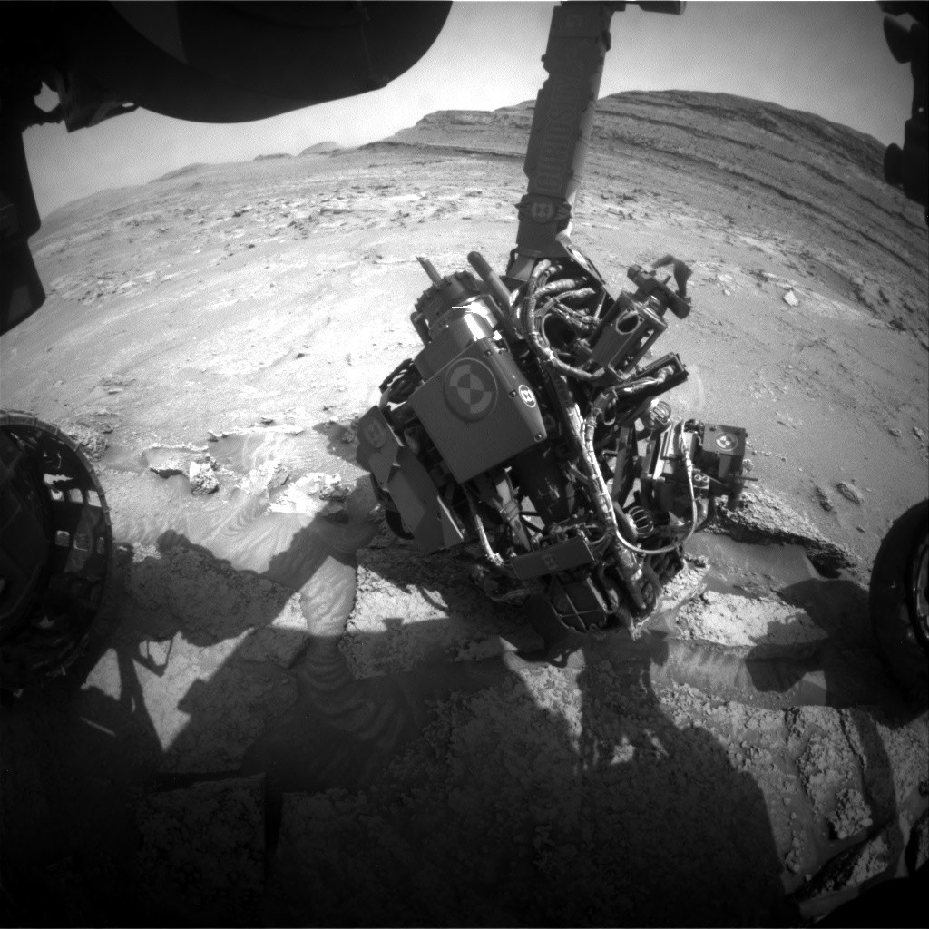NASA Curiosity rover's robotic arm with APXS spectrometer analyzing Martian rock sample on Mount Sharp