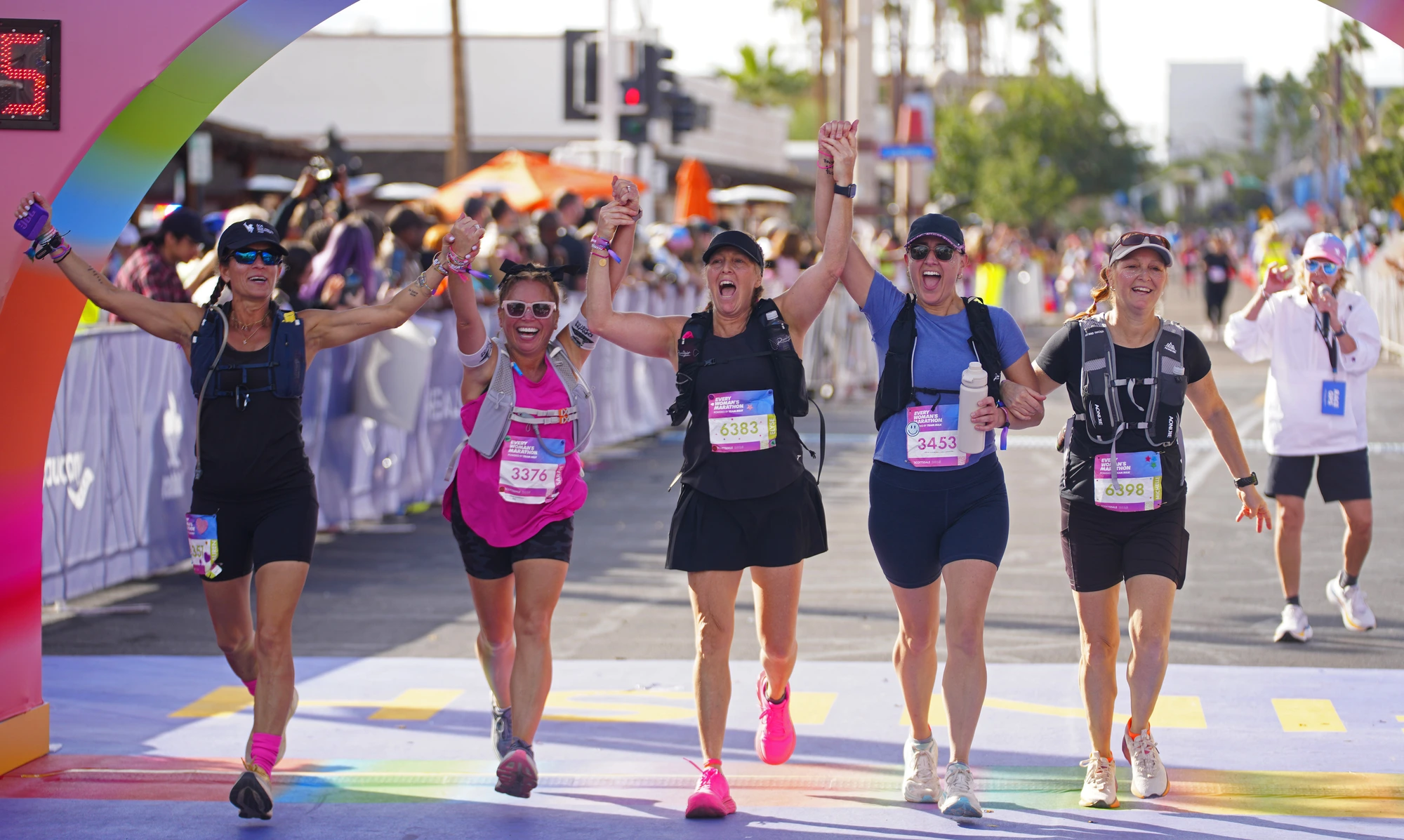 Group of diverse adults jogging together outdoors in morning sunlight, smiling