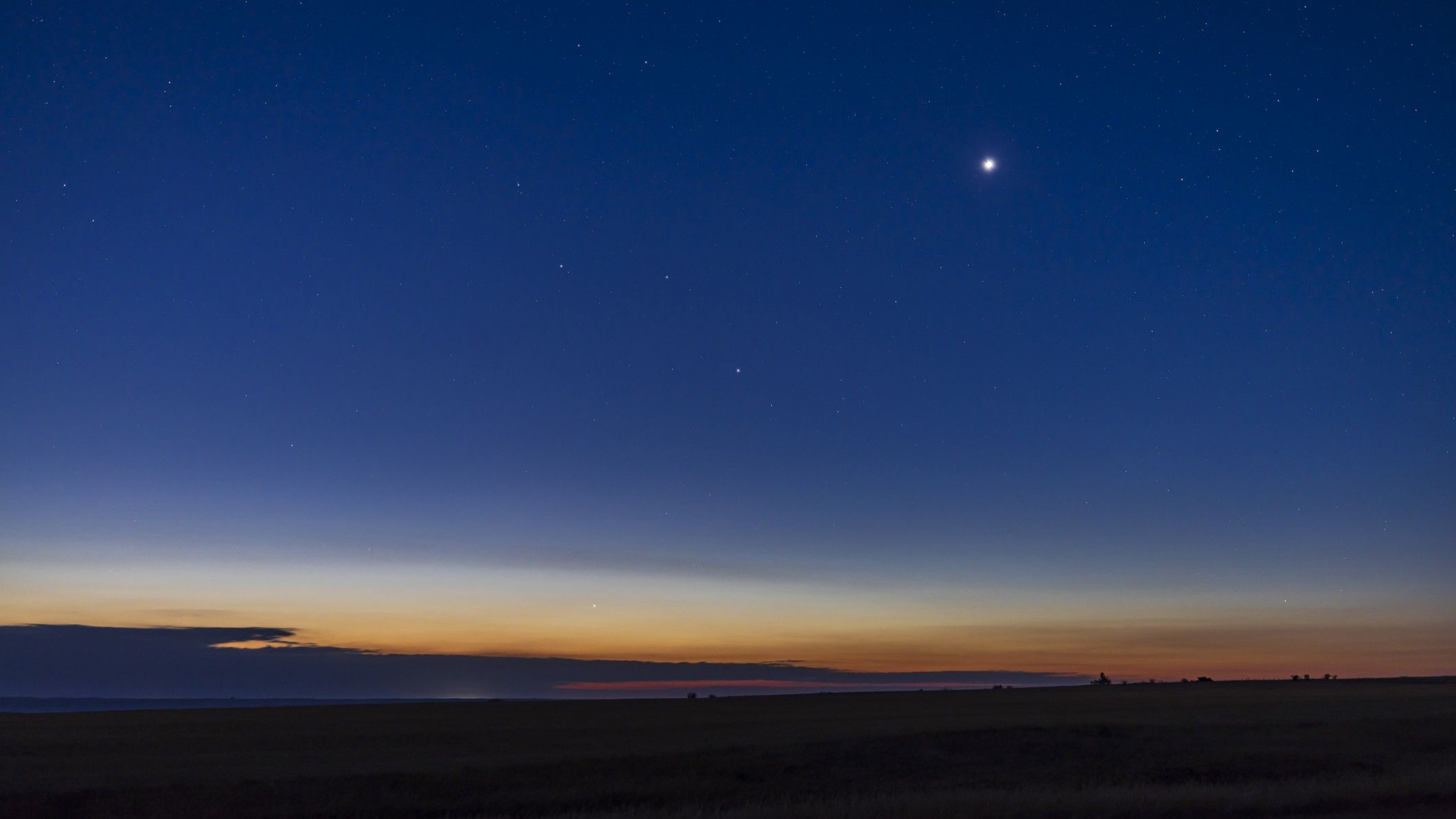 Brilliant Venus shining as bright evening star in twilight sky above horizon
