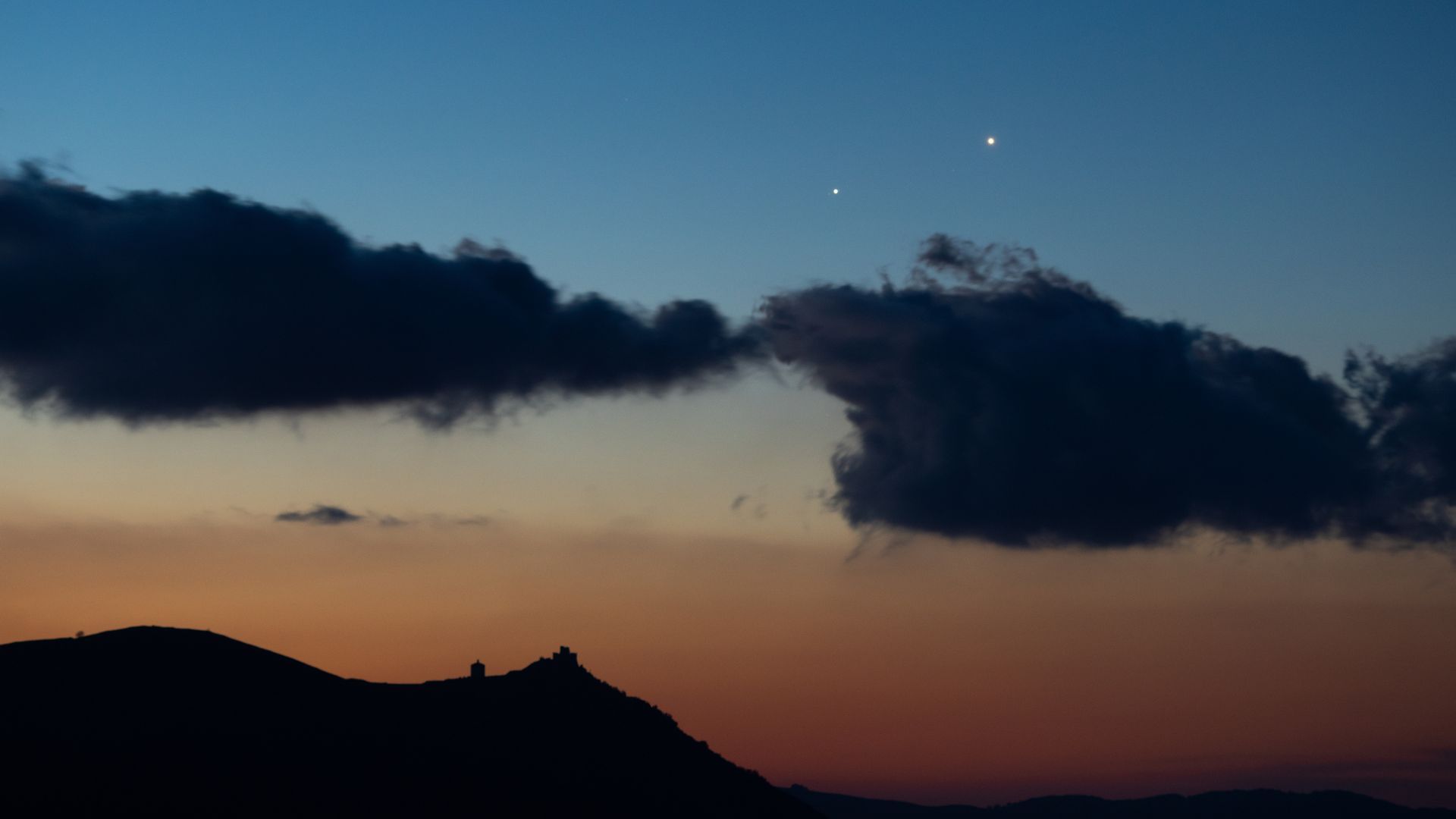 Three bright planets Jupiter Venus and Mercury aligned above western horizon at sunset