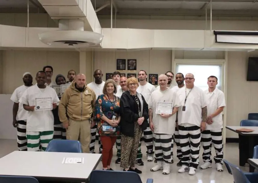 Group of incarcerated men at graduation ceremony for trauma recovery program completion