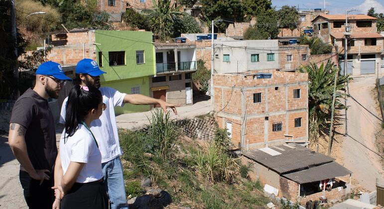 ** Community members walking through upgraded informal settlement with improved housing and infrastructure