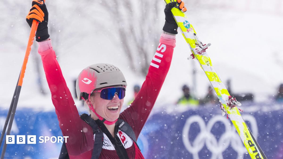 Ski mountaineering athlete sprinting uphill wearing skis through heavy snowfall at Olympic venue