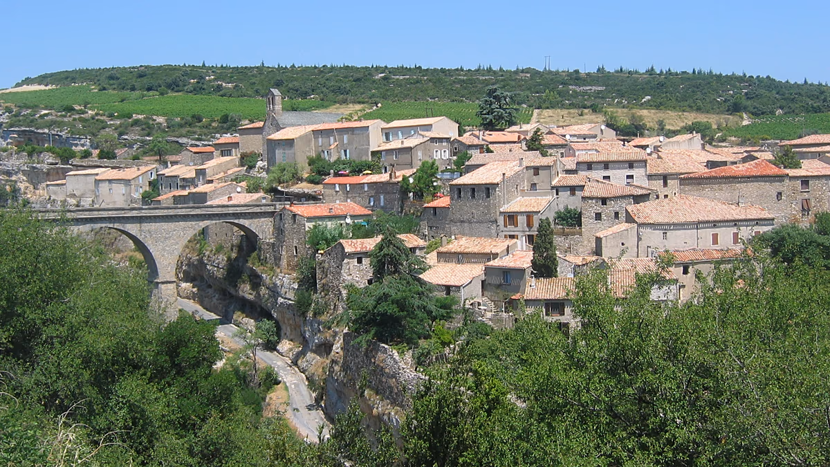 Stone cave dwelling carved into hillside in Trôo village, France, with entrance and windows visible