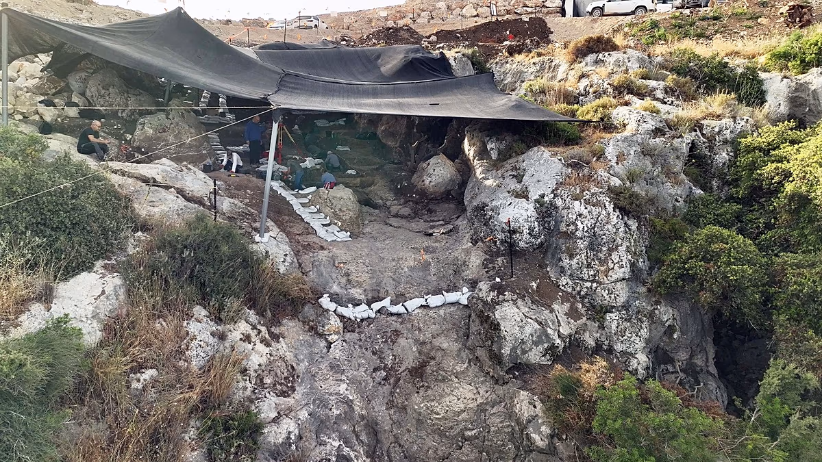 Archaeologists excavating inside ancient sealed cave in northern Israel showing preserved prehistoric layers