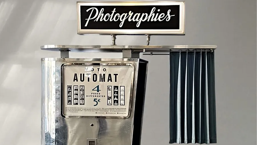 Person pulling back curtain of vintage black and white photo booth in classic style