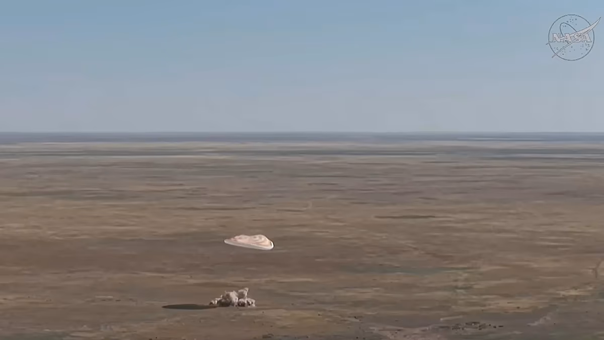 Soyuz spacecraft capsule landing in Kazakhstan desert with parachutes deployed after ISS mission