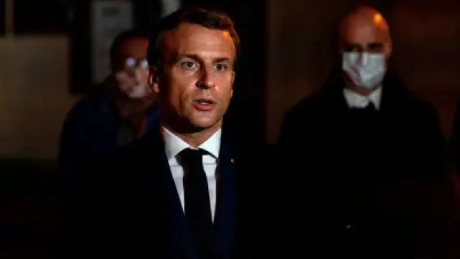 ** French President Emmanuel Macron speaking at podium about protecting children from social media