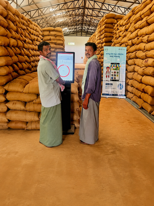 Indian farmer checking grain stored in modern village warehouse facility in rural Bihar