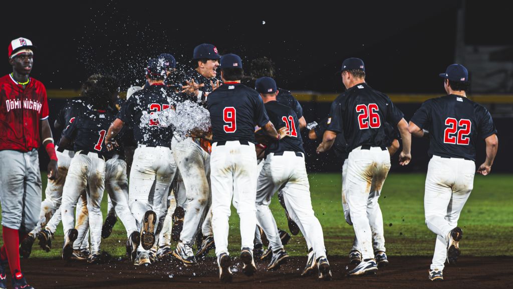 Team USA under-15 baseball players celebrating in a championship dogpile after winning gold medal