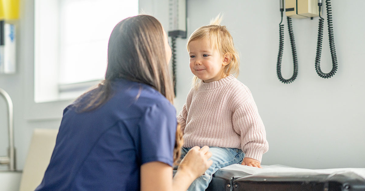 Young child being measured for height by doctor in pediatric medical office