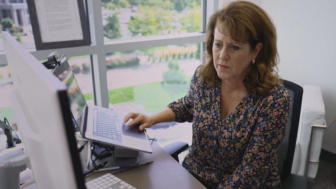 Jenny Ahlstrom, Utah mother of six and cancer survivor, smiling while working on HealthTree Foundation platform