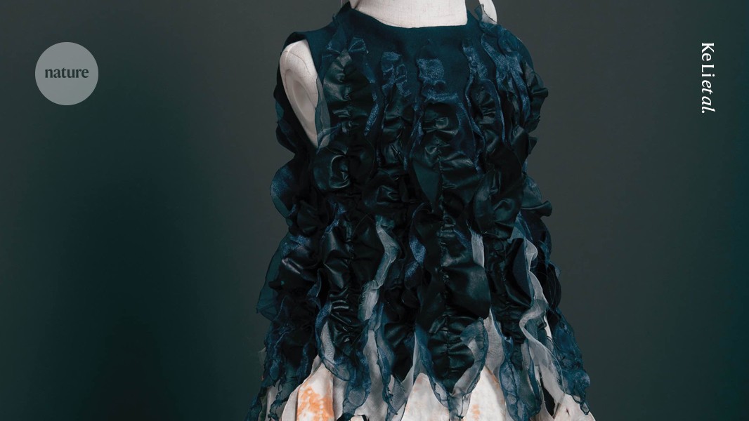 Model wearing dress made from living fungal filament textile fabric in laboratory setting