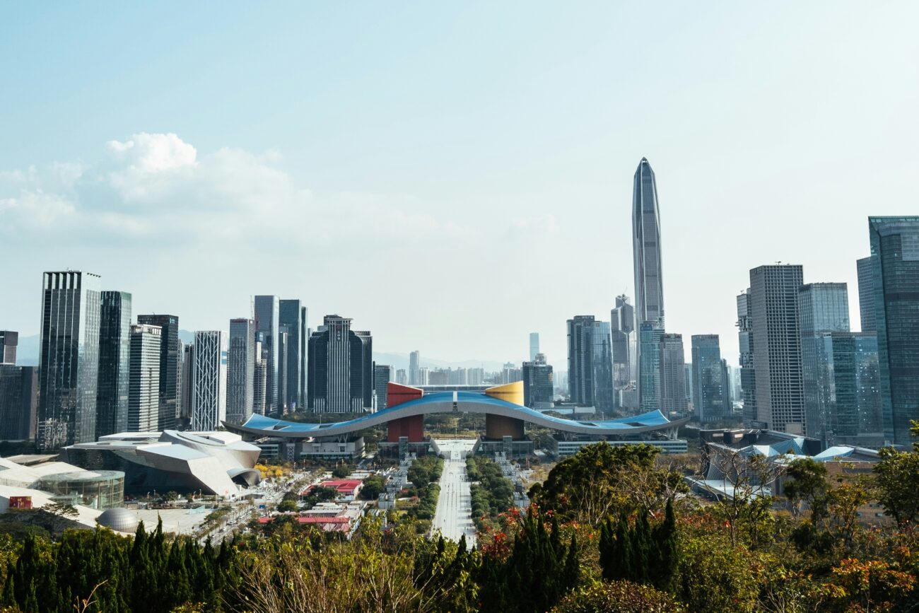 Aerial view of Shenzhen Deep Bay showing contrast between dense city skyline and green rural landscape with oyster rafts