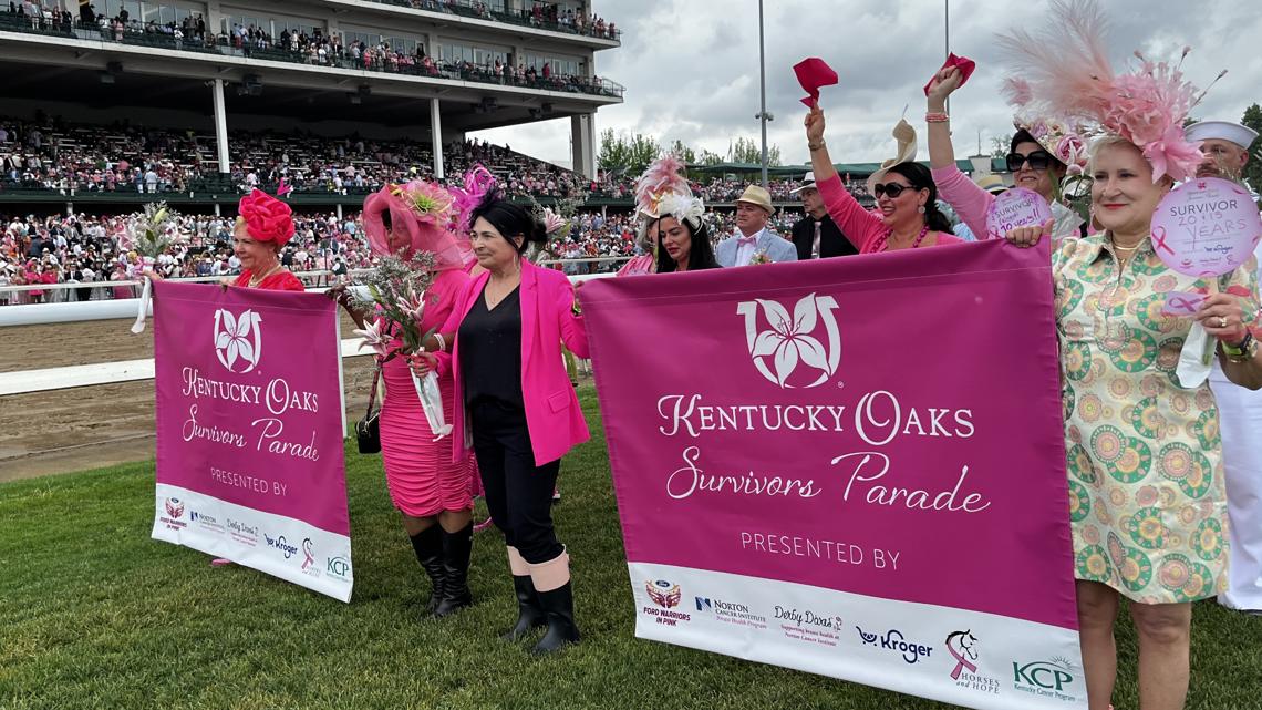 Cancer survivors in pink shirts walking together around Churchill Downs racetrack during annual parade