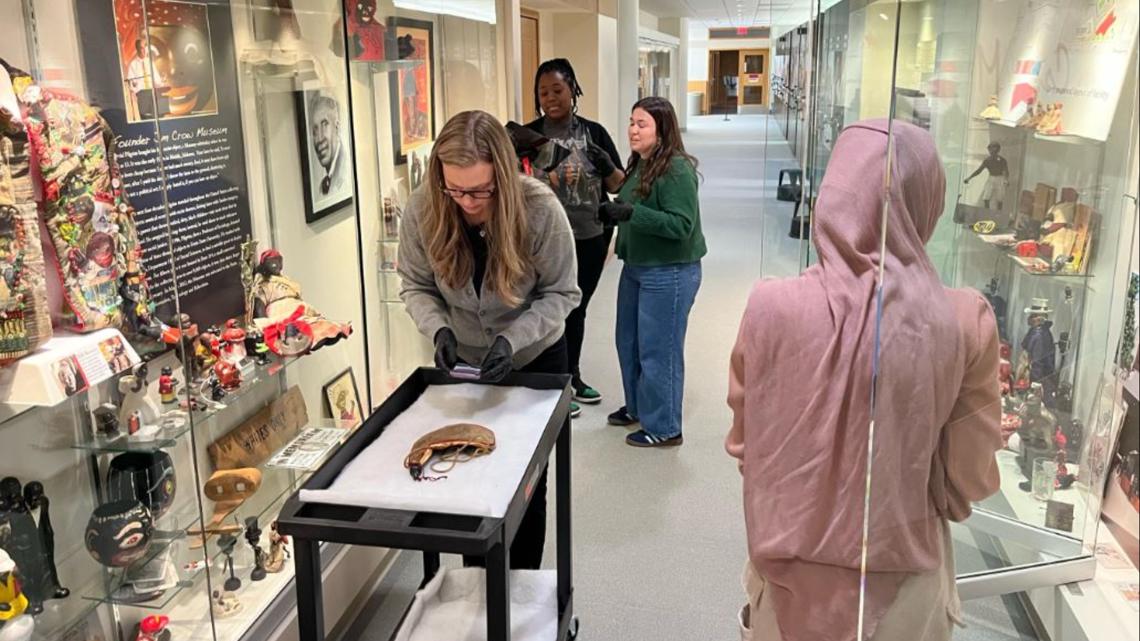 Volunteers carefully packing historical artifacts in archival boxes at Ferris State University's Jim Crow Museum
