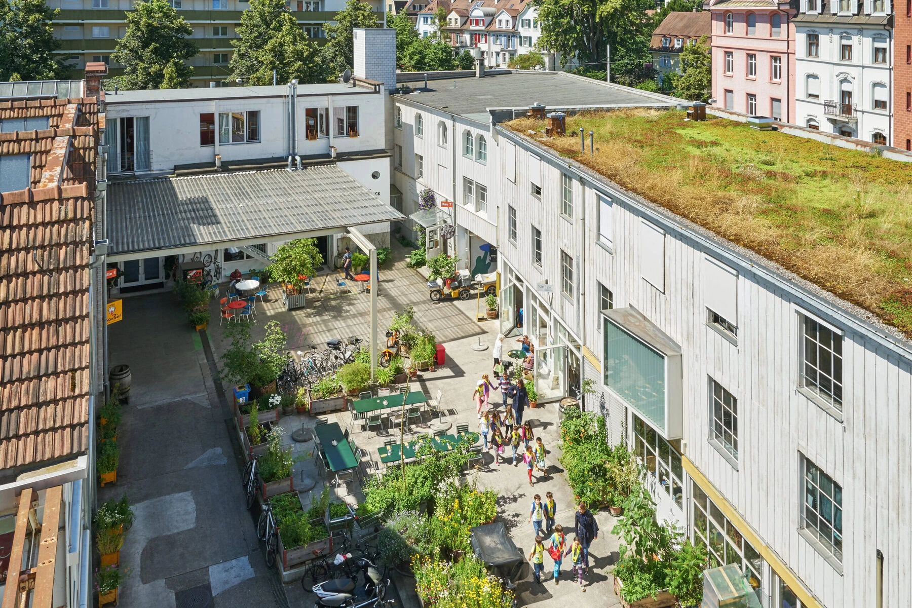 Swiss architect Barbara Buser stands on balcony overlooking renovated industrial building courtyard